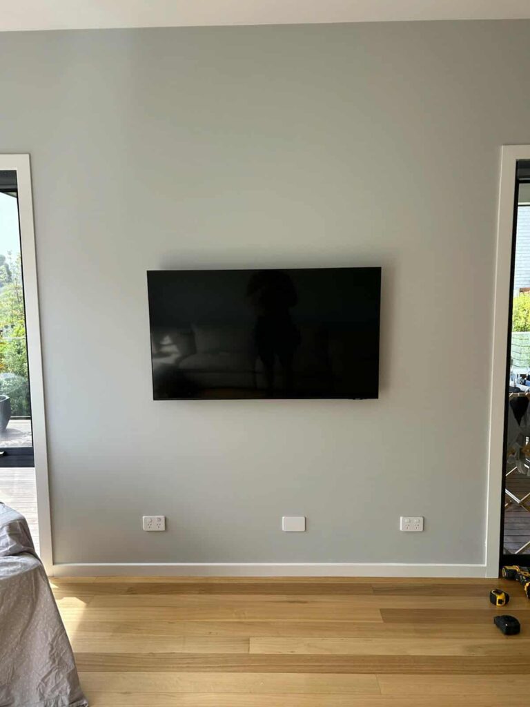 Home Wall-mounted TV installed by Seaside Electrical with power, HDMI, and coax cables neatly hidden behind the wall